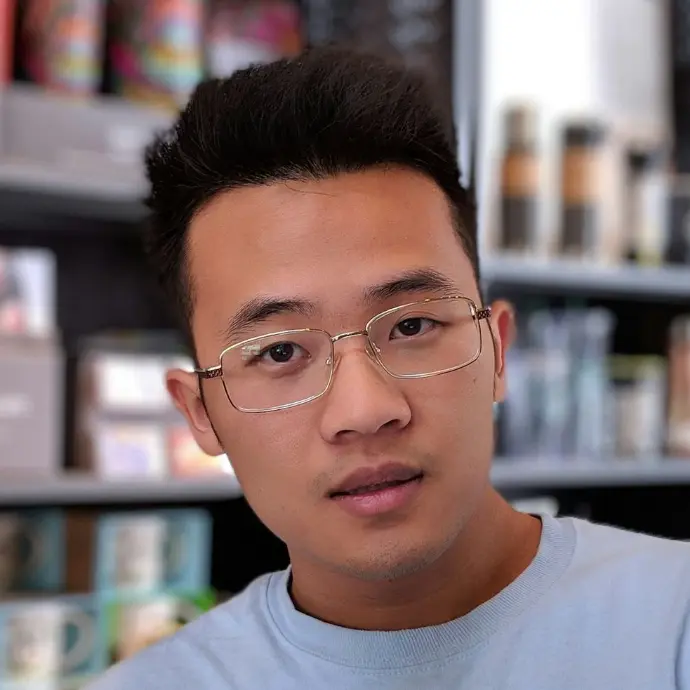 man wearing eyeglasses and blue shirt inside coffee shop